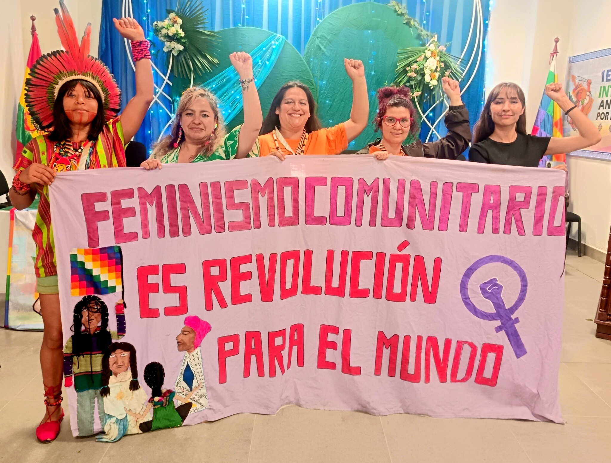 Mujeres de distintas comunidades levantan los puños en una actividad feminista